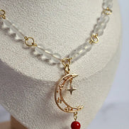 Weiße Perlenkette mit Mondanhänger an Goldkette