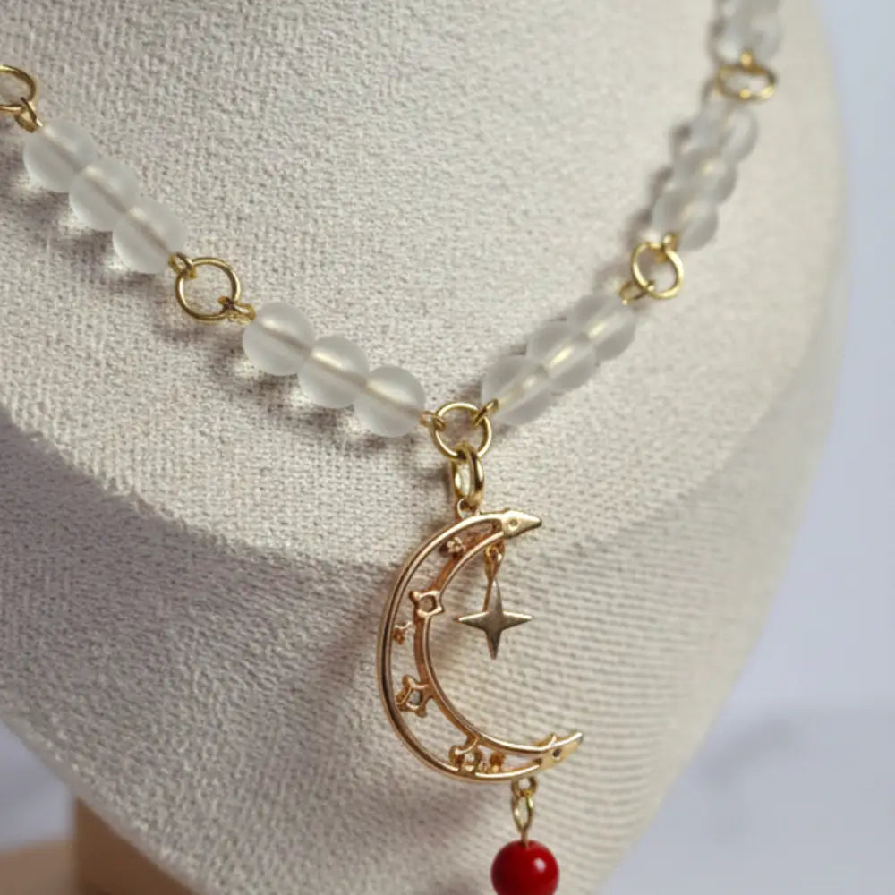 Weiße Perlenkette mit Mondanhänger an Goldkette