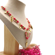 Rosa und metallisch-goldene Perlenkette mit Schmetterlingsanhänger an einer Goldkette