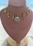 dreampunk.arts gold-tone link necklace featuring nautical starfish, moon, and blue shell charms on a display bust.