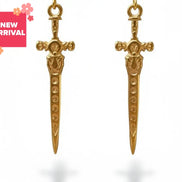 dreampunk.arts gold sword earrings with detailed fantasy knight design hanging on a string against a white background