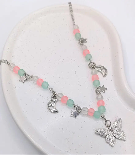 Pastellfarbene Edelstahlkette mit rosa und mintgrünen Perlen, Mondanhängern, Sternen und einem Schmetterlingsanhänger mit silberfarbener Kette